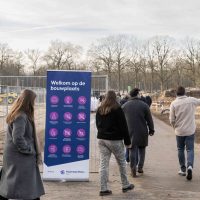 Start bouw Bosrijk Mariëndaal in velp: bezoekers lopen via de bouwplaats langs een welkomsbord richting het terrein.