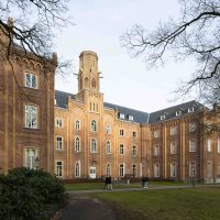 Monumentaal bakstenen kloostergebouw op landgoed Mariëndaal, omgeven door bomen en wandelpaden.