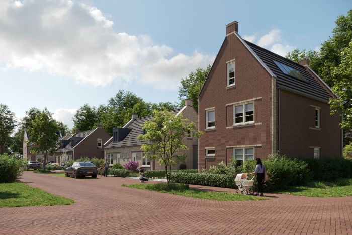 Vrijstaande bakstenen woningen in Bosrijk Mariendaal (Velp) langs rood klinkerwegdek; groenstroken, geparkeerde auto’s en wandelaar met kinderwagen, zonnige dag.