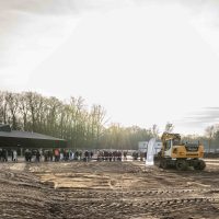 Start bouw Bosrijk Mariëndaal in velp : publiek verzameld langs de bouwplaats terwijl een graafmachine klaarstaat op het terrein.
