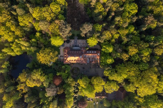 Top-down luchtfoto: historisch landhuis met binnenhof en terrassen tussen groene boomkronen — Ontwikkeling Landgoed De Utrecht Esbeek