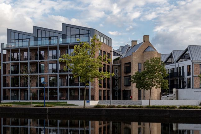 Waterfront nieuwbouw met bakstenen gevels, grote ramen en bomen langs de kade — Ontwikkeling DOK40 Eindhoven