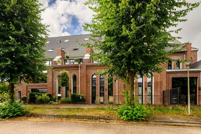 “Bakstenen façade met ritmische arcades en grote ramen, geïntegreerd woonproject — Transformatie Antonius van Paduakerk Valkenswaard