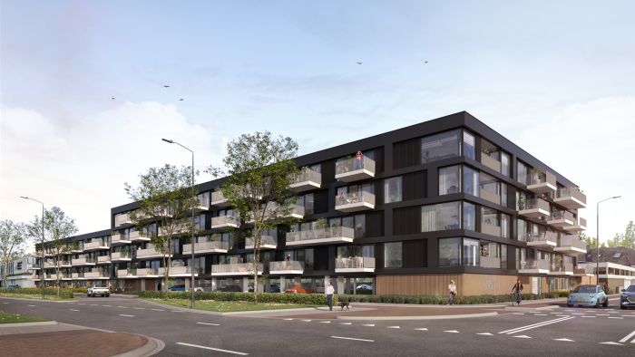 Impressie van Maison L’Europe in Helmond: modern hoekvormig appartementencomplex met donkere gevel en uitspringende witte balkons langs beide straten, omgeven door jonge bomen, voetgangers en enkele auto’s onder een heldere lucht.