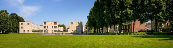 Brede zichtlijn over grasveld naar woonensemble met ritmische bomenrij — Ontwikkeling De Vijf van Vorst Eindhoven