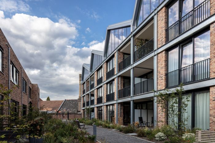 Balkons van het nieuwbouwcomplex DOK40 in Eindhoven met uitzicht op de groene binnentuin en de omliggende woningen.