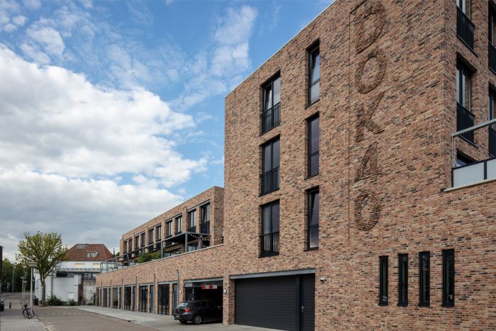 Voorzijde van het nieuwbouwcomplex DOK40 in Eindhoven, met moderne gevels en straatbeeld van de woningen en appartementen.