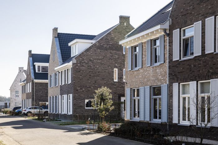 Rijwoningen met bakstenen gevels langs woonstraat in nieuwbouwwijk