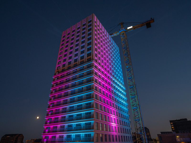 Een gebouw dat blauw en roze licht geeft